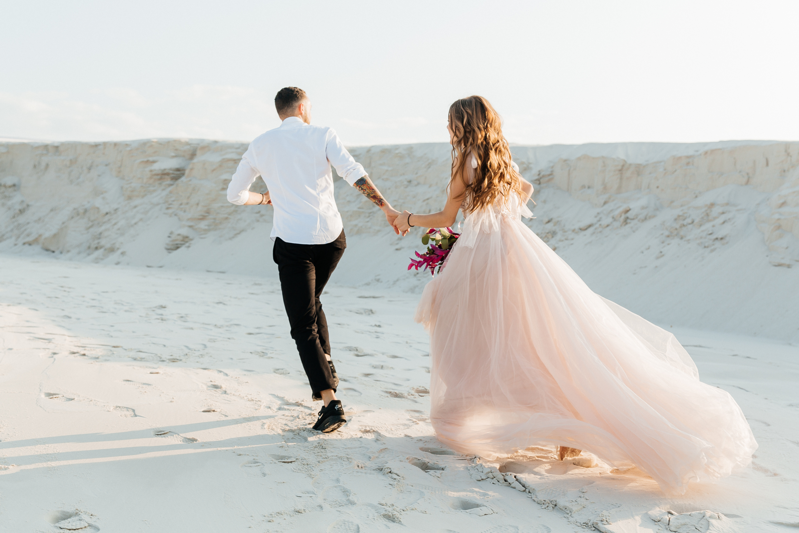 Love Story of a beautiful couple in a pink wedding luxury dress with a bouquet in the Sahara desert, sand, dunes Beachview Restaurant Bar Venue Fort Walton Beach Wedding